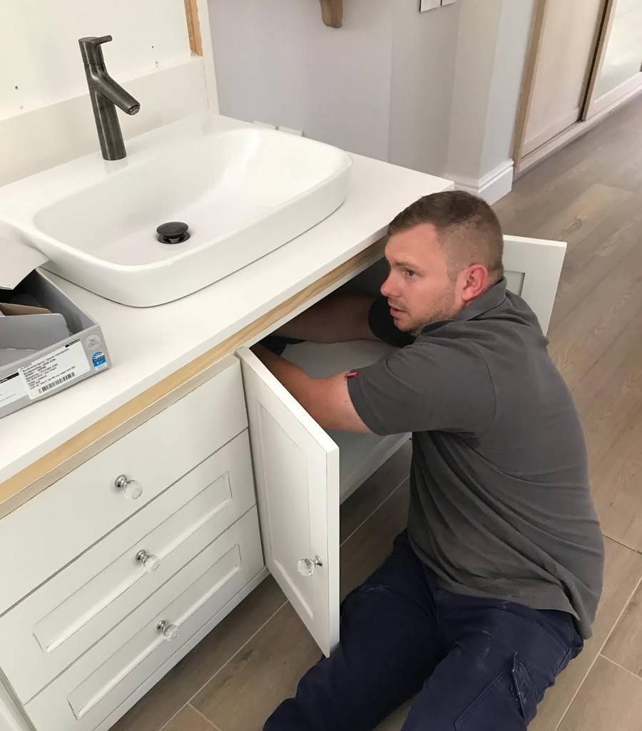 Chris from Blue Tech Plumbing fitting the plumbing under a new bathroom vanity